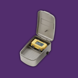 Open metal case with a yellow digital meter resting on a perforated tray, suggesting a portable laboratory instrument.